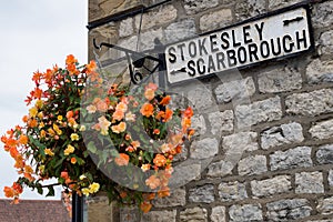 Flower Hanging Basket with road sign, Stokesley or Scarborough