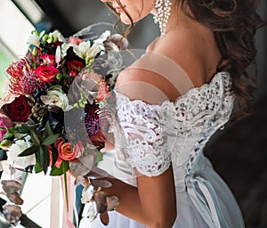 the flower holding by bride neare the window