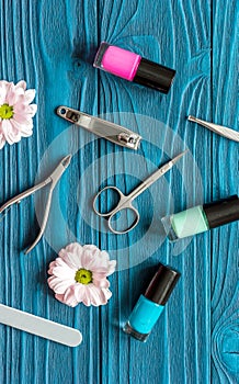 Flower, nail polish and manicure set on dark wooden background