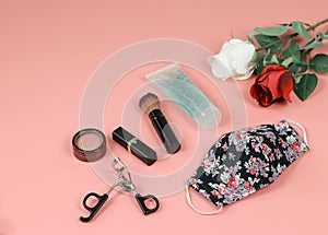 Flower pattern fabric mask , woman`s make up accessories,alcohol sanitizer hand gel ,red and white roses on pink background.