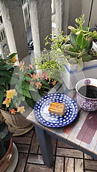 Flower pots, coffee and cake on the balcony in summerr