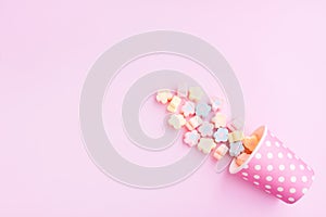Flower Shaped Marshmallows out of a pink paper cup with white dot on pink background