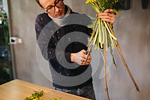 Flower shop make bouquet for a holiday. Family flower`s business. Beautiful flower composition. Detail. Close up