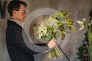 Flower shop make bouquet for a holiday. Family flower`s business. Beautiful flower composition. Detail. Close up