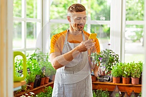 Flower shop owner taking picture of a flower pot.