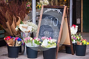 Flower shop sidewalk display with sign