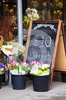 Flower shop sidewalk display with sign