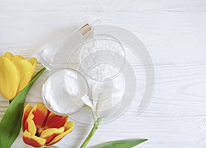 Flower tulip, cosmetic cream, treatment health ointment handmade salt on white wooden background