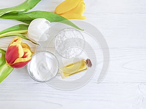 Flower tulip, cosmetic cream, treatment product health ointment handmade salt on white wooden background