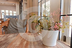 Flower vase on wooden table in coffeehouse