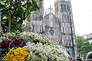 Flower vendor on Hanoi street at early morning with St. Joseph Cathedral church on background