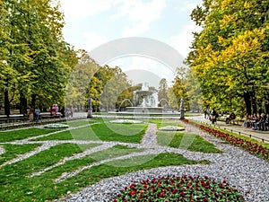 Flowerbeds with a fountain in the Saxon Garden in Warsaw Poland on an autumn sunny day. Beautiful scenery of the oldest public