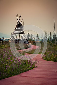 Flowered red clay walkway leads to a beautiful metal teepee at the Blackfeet Indian Memorial in Babb, Montana