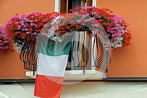 Flowering balcony with Geraniums and the Italian flag