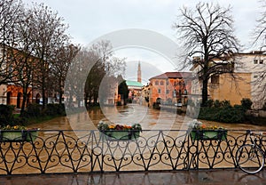 Flowerpots on the FURO Bridge and under the swollen RETRONE River during the flood in the city of Vicenza in Italy due to climate
