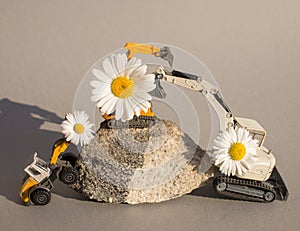 Flowers on arrows of three toy models of construction vehicles - excavators