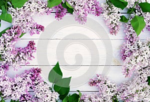 Flowers background. Bouquet of a branch of lilac spring flowers on a white wooden background.