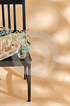 flowers in basket on chair over beige background