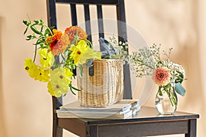 flowers in basket on chair over beige background