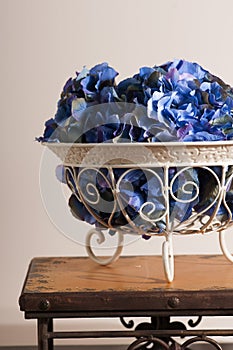 Flowers of blue hydrangeas in a metal florid forged vase