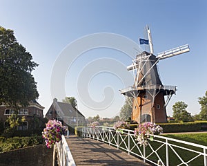 Flowers on bridge and old windmill in dutch town of dokkum