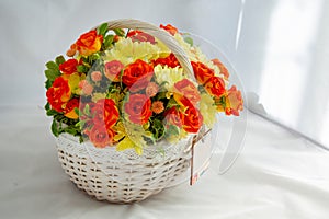 Flowers bunch wicker basket, with red roses and yellow chrysanthemums in gift box