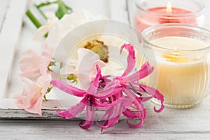 Flowers and candles on old wooden background