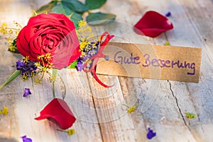 Flowers and card with german text, Gute Besserung, means get well soon