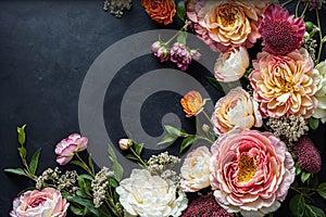 Flowers composition with roses, peonies and decorative flowers on dark background. Top view. Flat lay. Floral border and frame for