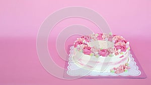 Flowers cream birthday cake over pink background