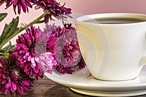 Flowers and Cup Of Coffee On The Wooden Table