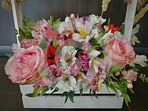 Flowers cute bouquet with roses and alstroemerias pink white green, wooden box photo