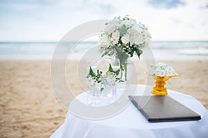 Flowers decorate at a wedding ceremony on the beach.