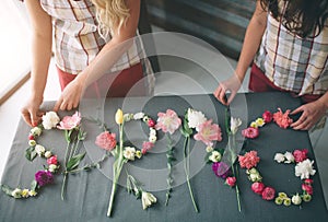 Flowers delivery top view. Florists creatin word SPRING made of flowers on background. Spring concept. Flat lay