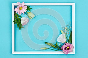 Flowers in frame isolated on blue background. Spring concept