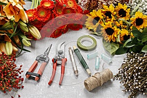 Flowers and garden tools on a gray stone background