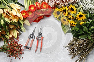 Flowers and garden tools on a gray stone background