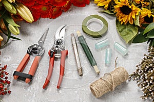 Flowers and garden tools on a gray stone background