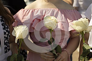 Flowers in the hands of the girls. The woman is holding a rose