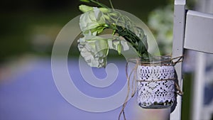 Flowers hanging in mason jar at wedding