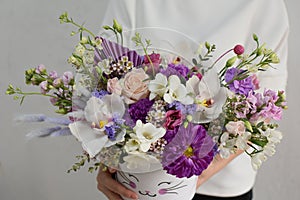 flowers in hat box. woman with a bouquet of flowers. online catalog of flower delivery shop. plant composition