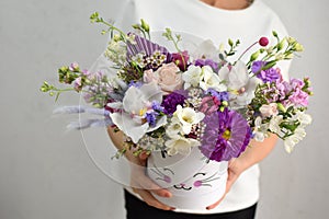 flowers in hat box. woman with a bouquet of flowers. online catalog of flower delivery shop. plant composition