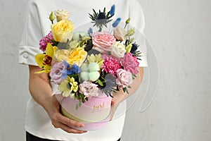 flowers in hat box. woman with a bouquet of flowers. online catalog of flower delivery shop. plant composition