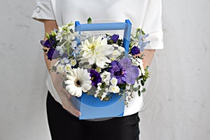 flowers in hat box. woman with a bouquet of flowers. online catalog of flower delivery shop. plant composition