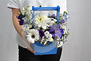 flowers in hat box. woman with a bouquet of flowers. online catalog of flower delivery shop. plant composition