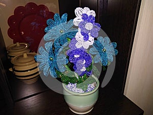 Flowers jewelry beads in pots on a dark background