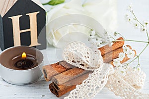 Flowers and lit candle, wooden letter H