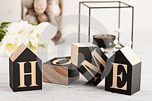 Flowers and lit candle, wooden letter Home