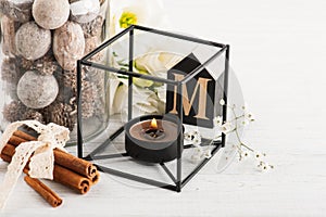 Flowers and lit candle, wooden letter M