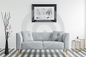 Flowers next to grey sofa with cushions in minimal living room i photo